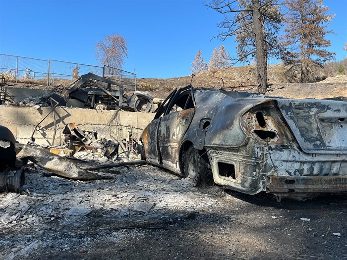 Abandoned, melted vehicles are scattered amongst the wreckage. 