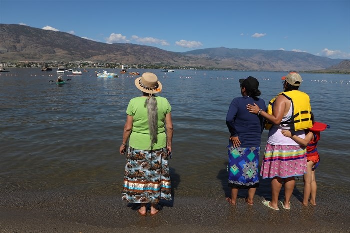 Community members watch as canoes set sail on the 2024 Suk?naqin canoe journey.