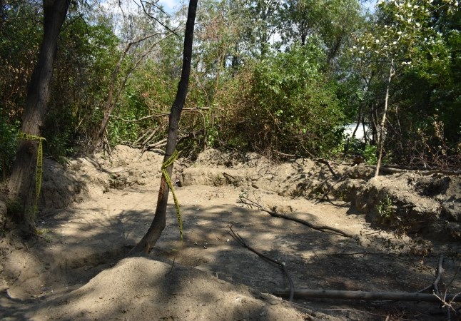 One of several unused former encampment sites near Richmond Avenue and Schubert Drive, where its former residents have dug spaces for their tents. The Halloween-themed tape tied to the trees reads 