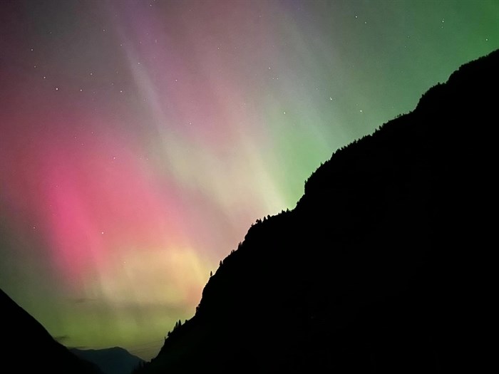 A silhouette of a mountain and colourful aurora borealis is seen in Lillooet. 