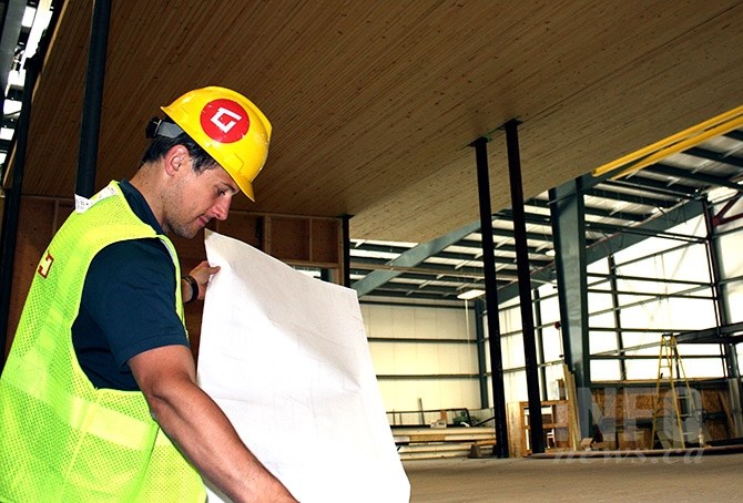 Karoleena Homes Co-founder Kris Goodman surveys blueprints in the company's manufactured home plant in Okanagan Falls. A Karoleena home was selected as the prize home for this year's PNE 