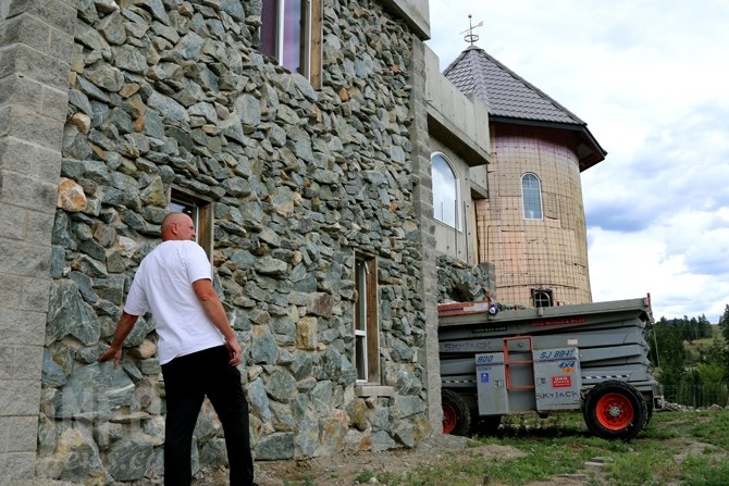 Rick Zinger explains the process of creating a stone finish on the exterior of the home.