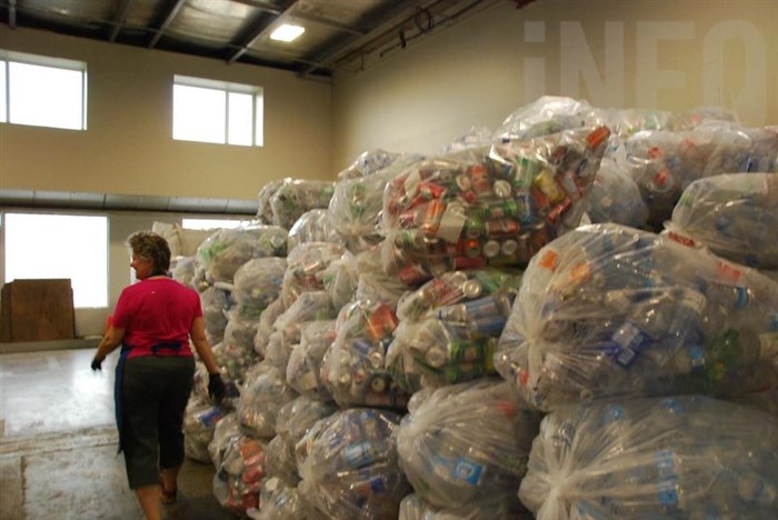 Manager Judith Jordan of General Grants Sahali walks past a mountain of recyclables collected during the Emterra Environmental strike.