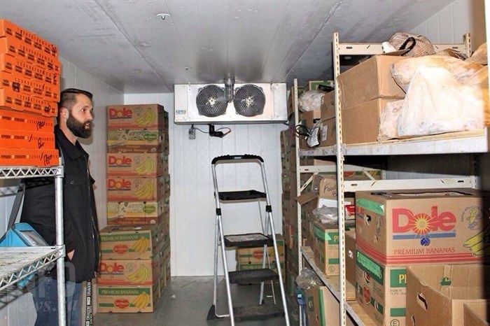 Wes Graham shows off the food bank's freezer which is holding multiple meat items to include in the Christmas hampers this year. 