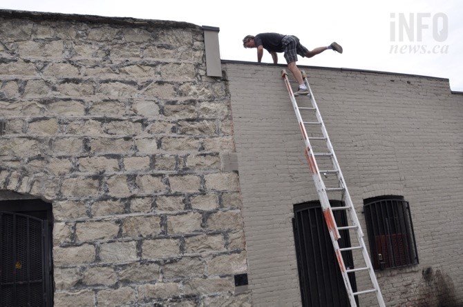 Jim Belgin works stringing light on the building adjacent to the Laneway Project