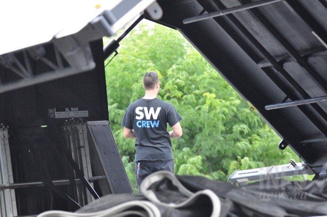 A worker is framed by the collapsible stage being raised, Wednesday, Aug. 10, 2016, for the innaugural Rock the Lake Festival in Kelowna this weekend.