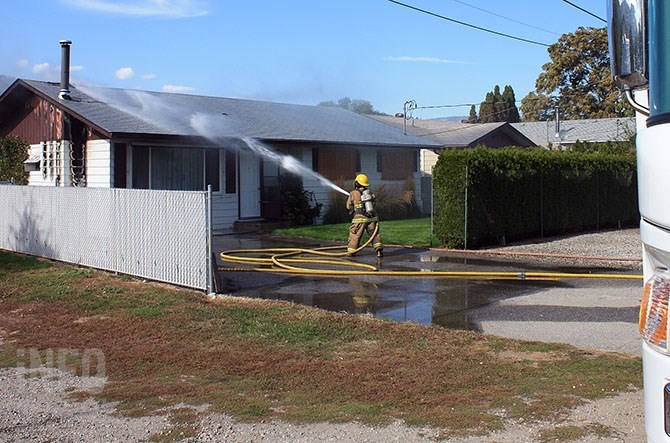 Okanagan Falls firefighters battle a blaze on Birch Street in the community this afternoon, Sept. 30, 2016.