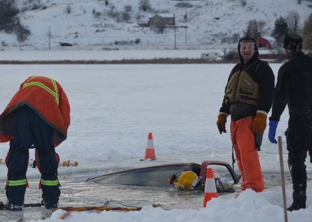 A scuba diver plunges into Swan Lake to recover a sunken truck Jan. 10, 2017. 