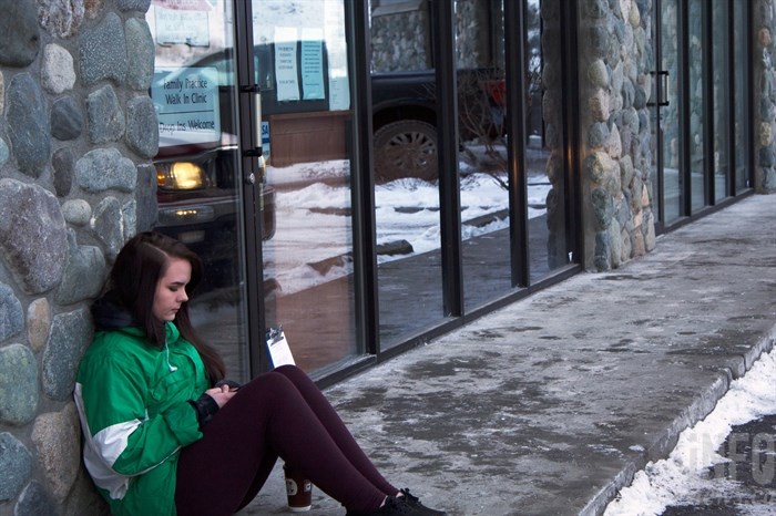 Chloe Ovington waits outside Summit Medical Clinic to see a doctor. She doesn't have a vehicle, so she walks from her house.