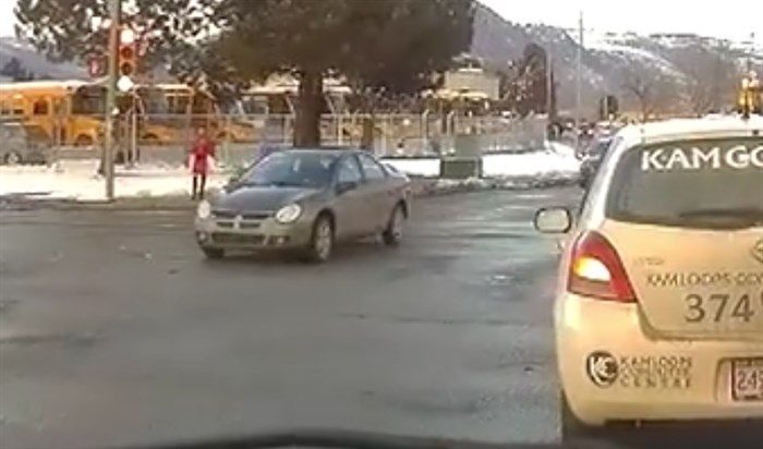 In a screen cap of the video posted by Marc Smith on Facebook a car runs a red light in front of cars turning left on a green signal.