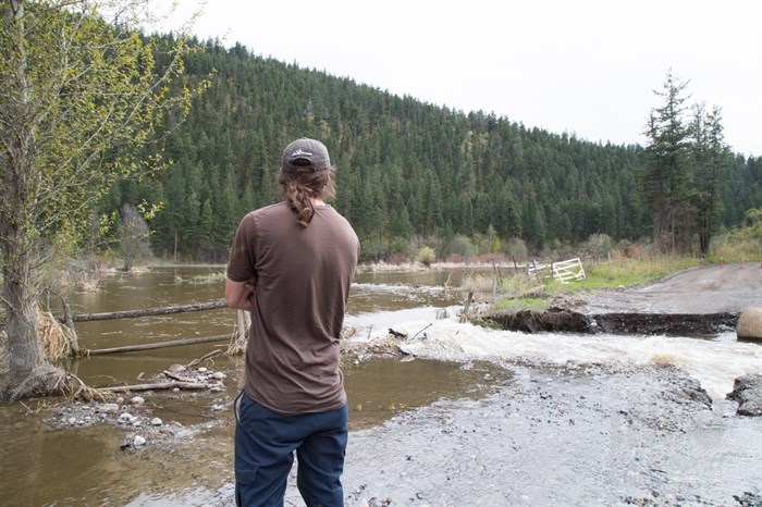 A resident looks on as Campbell Creek Road gets higher each day. 