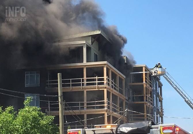 Smoke pours from the building under construction on Truswell Road July 8, 2017 as firefighters fight the blaze.