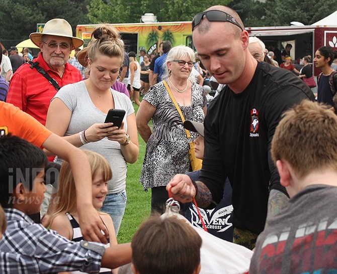 Canadian Forces Skyhawks Precision Parachute Team member Master Cpl. Jeremy Canfield shows members of the crowd how to pack a parachute following a demonstration jump at Penticton Peachfest 2017, Aug. 10, 2017.