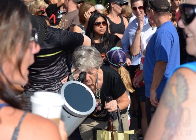 Russel Earnshaw peeks through the telescope to view the eclipse. 