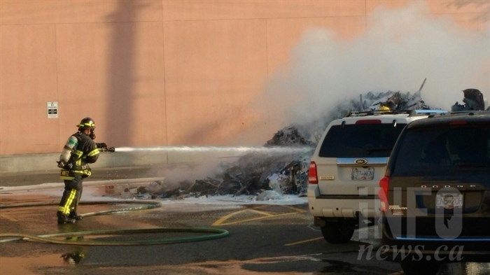 Kamloops fire crews work to extinguish a fire in a load dumped by a garbage truck in downtown Kamloops, Thursday, Oct. 5, 2017.