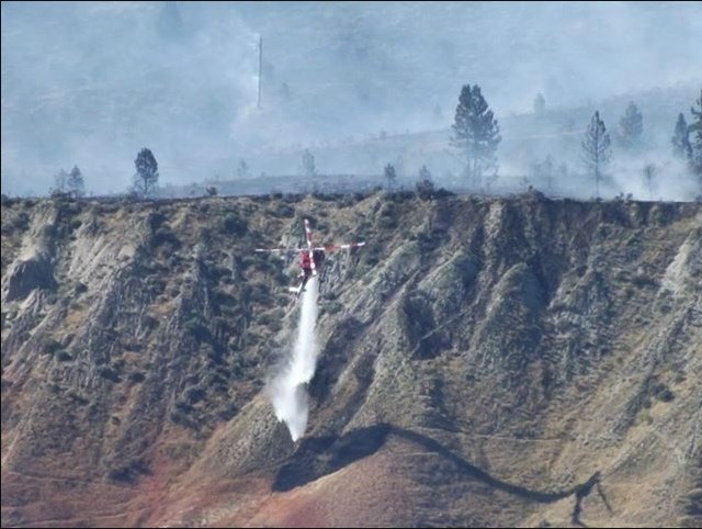 This photo submitted by reader Nathan Richie shows the state of the Shuswap Road fire on July 12, 2018. A tanker drops water in the vicinity of the blaze.