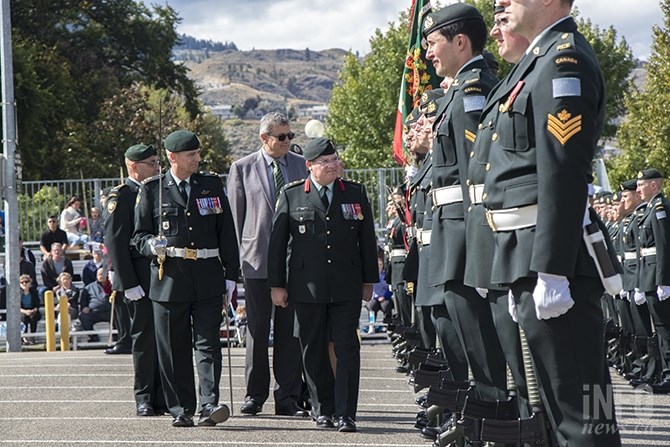 Colonel Paul Ursich leads officials like Commanding Officer Lieutenant-Colonel Normand Dionne, and Major Vecchio in greeting officers standing at attention for the ceremony.