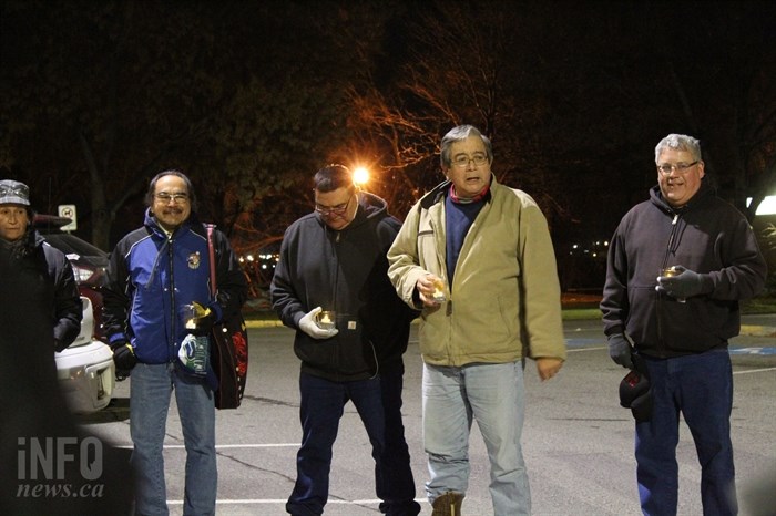 Antoine LaRue, second from right, gives the opening prayer before walkers began departing from the parking lot at Riverside Park.