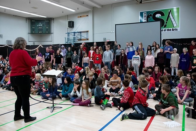 Ellen McMillan leads the KSA Secondary Choir in song as many of the other age groups watch and listen. Aiden Henderson stands with his peers, as Lucas Woods turns to face the older group.