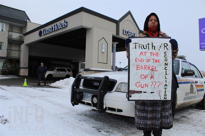 Snutetkwe Manuel poses with a sign outside the Coast Kamloops Hotel and Conference Centre while Prime Minister Justin Trudeau hosts a Liberal party fundraiser inside on Wednesday, Jan. 9, 2019.