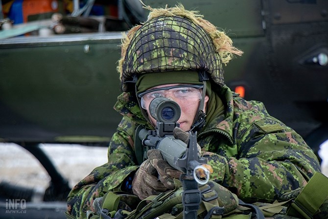 After getting out of the helicopter soldiers had to mount their weapons facing away from the aircraft. Here a man holds his gun fixed with a yellow stopper, meaning it is being used for practice. The weapons were loaded with blanks for the exercise. 