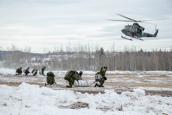 The soldiers wait in formation for the helicopters to land. They know exactly which seat they will take and where to put their equipment.