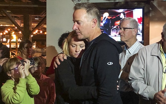 Stephen Fuhr is embraced by his partner Annie after Conservative Tracy Gray took the lead in Kelowna-Lake Country.