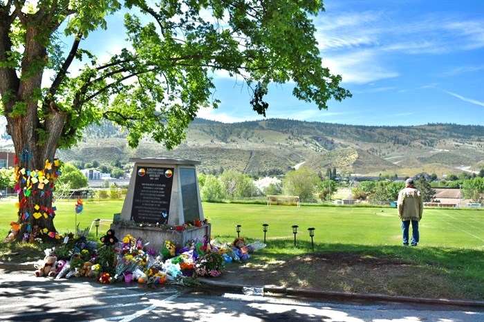 A man faces away from the former Kamloops Residential School, towards the South Thompson River.