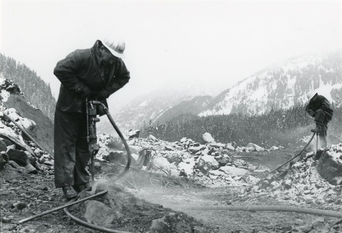 Staff drilling to clear a new route through the slide site on BC Highway 3.