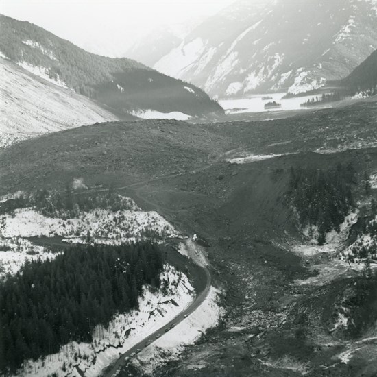 Cars are parked along BC Highway 3 at the western edge of the slide site.