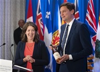 British Columbia Premier David Eby, right, gifts a bottle of B.C. wine to Alberta Premier Danielle Smith while speaking to reporters at the Council of the Federation meetings in Halifax on Tuesday, July 16, 2024.