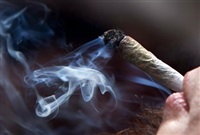 FILE PHOTO - A young man smokes a marijuana joint during a rally in downtown Vancouver, B.C., on Wednesday April 20, 2011. 